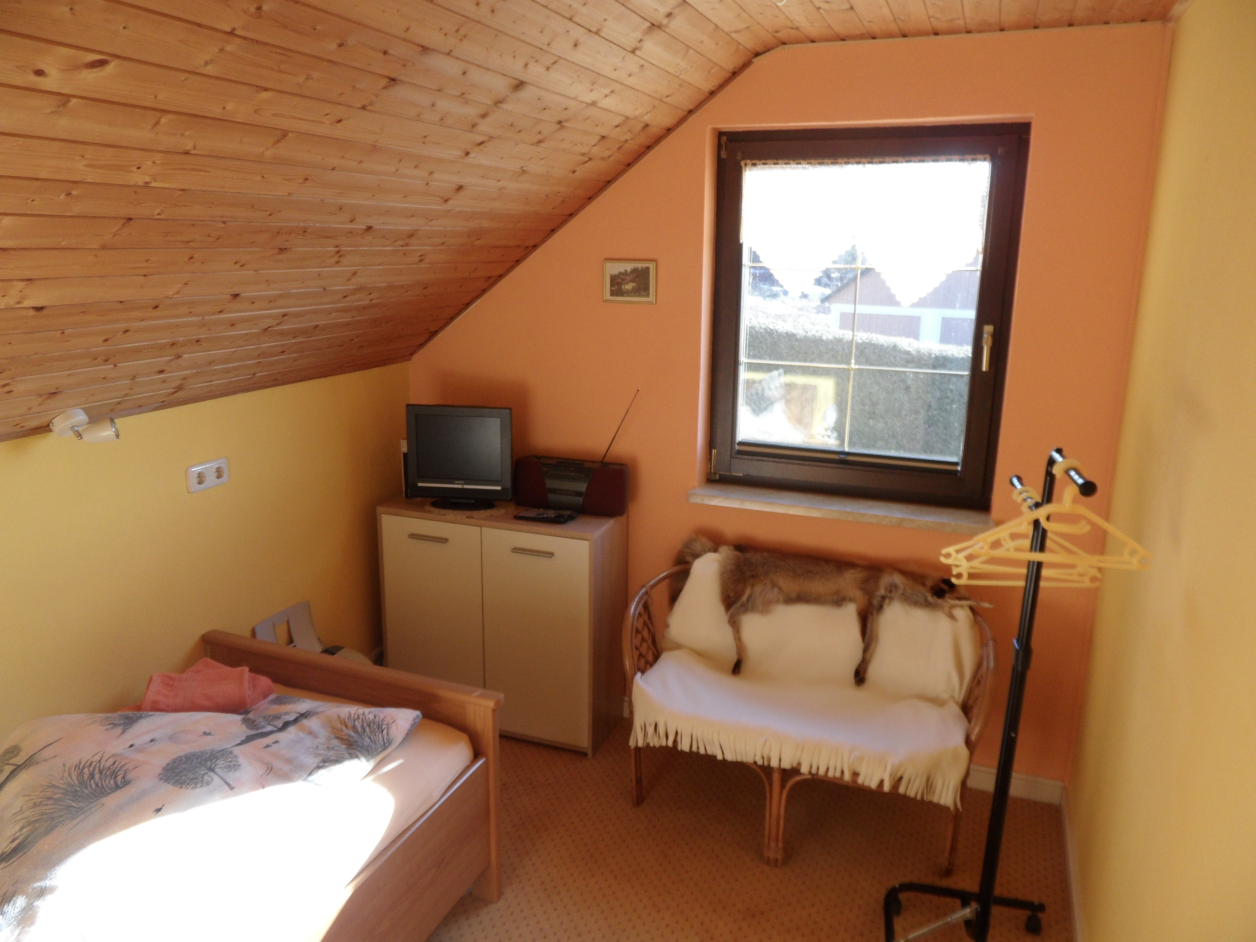 Einzelzimmer mit Bett, Schrank und LED-TV